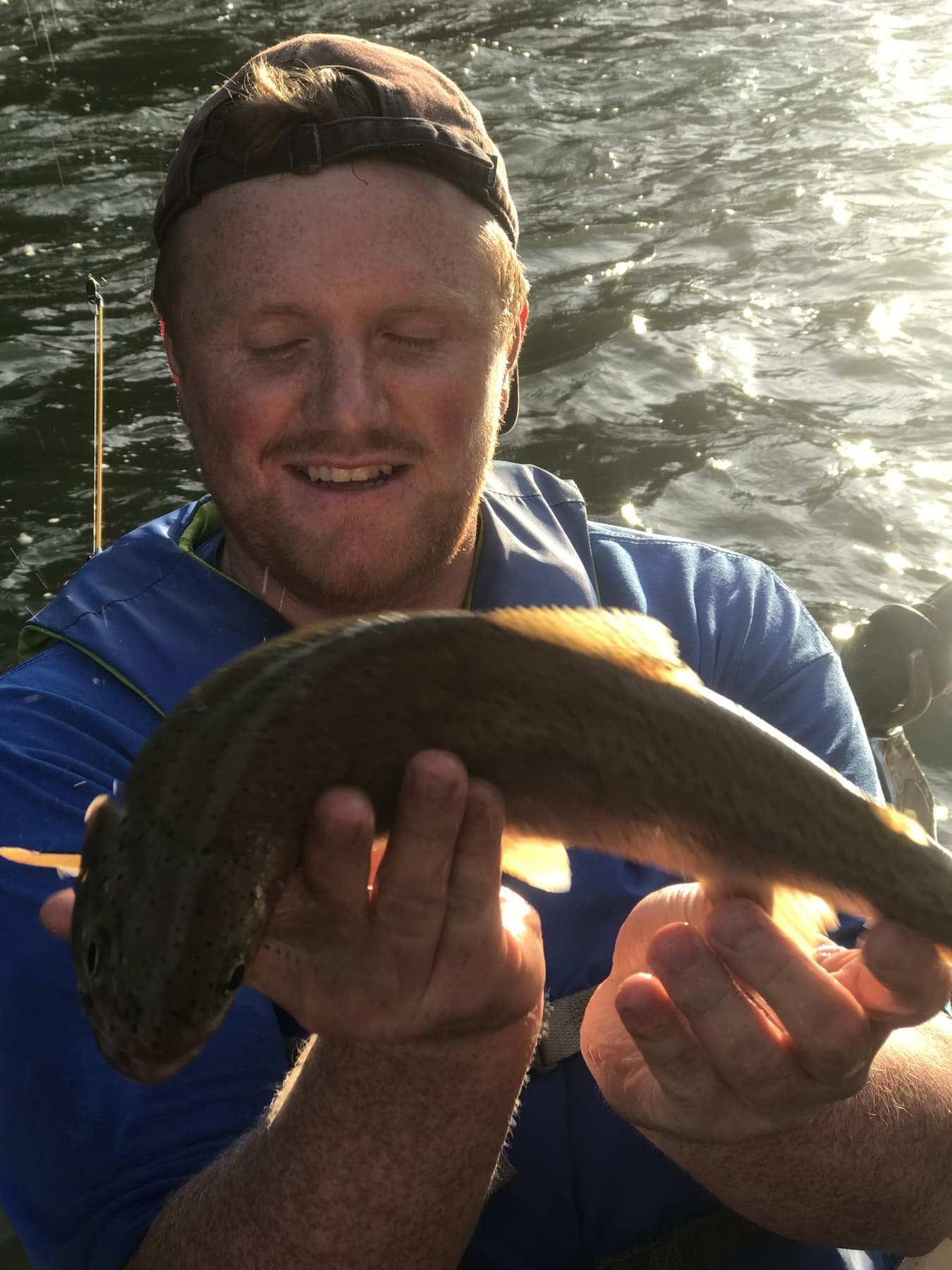 Angler admiring a trout in golden hour light